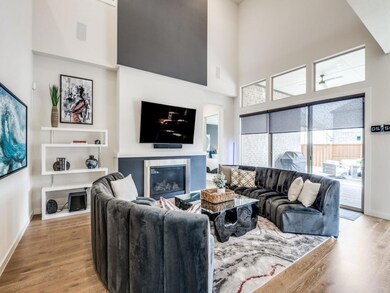 Living room with a high ceiling and light hardwood