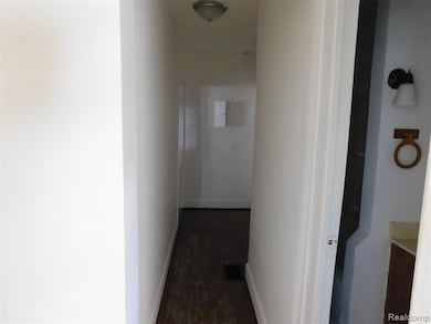 Hall with baseboards and dark wood-type flooring