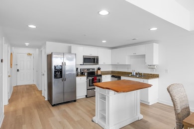 Kitchen with a sink, white cabinetry, appliances w