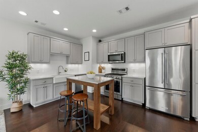 Kitchen with gray cabinetry, appliances with stai