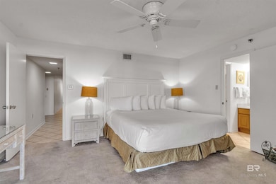 Bedroom with light carpet, light tile patterned floors, ceiling fan, and a textured ceiling