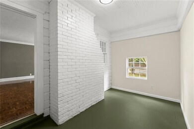 Empty room featuring crown molding and baseboards