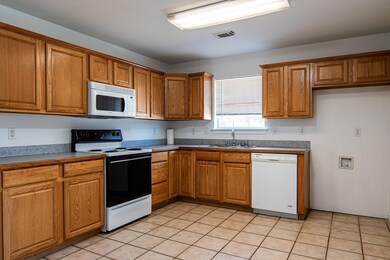 Kitchen featuring sink, white appliances, and ligh