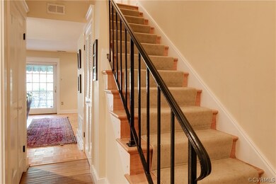 Entry foyer with wood floor and steps with runner