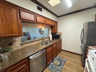Wood grain cabinets, granite counters, dishwasher and sink
