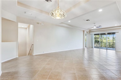 Unfurnished room featuring a raised ceiling, visib