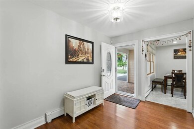 Foyer entrance with a baseboard heating unit and dark wood-style floors