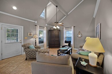 Living room with ceiling fan, light tile patterned