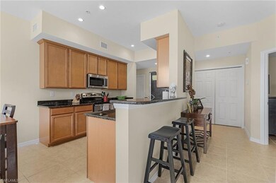 Kitchen with dark stone countertops, light tile pa