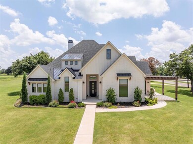 Modern farmhouse style home with brick siding, a front yard, and a standing seam roof