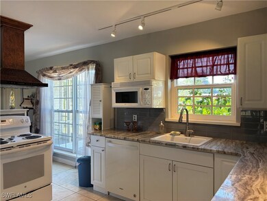 Kitchen featuring white cabinetry, backsplash, whi