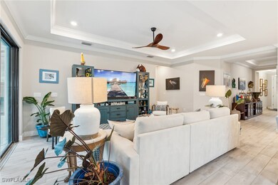 Living area featuring a raised ceiling, light wood