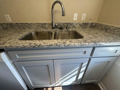 Details with a textured wall, a sink, and light gr