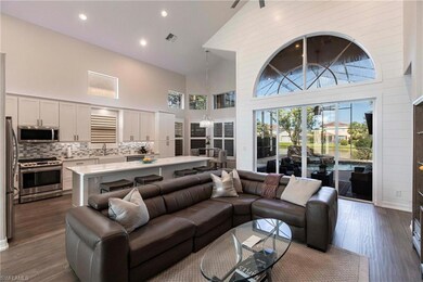 Living area with high vaulted ceiling, dark wood-type flooring, plenty of natural light, and recessed lighting