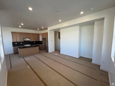 Kitchen featuring backsplash, an island with sink, dark countertops, recessed lighting, and open floor plan