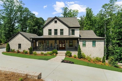 View of front of home featuring a porch, brick siding, and a front yard