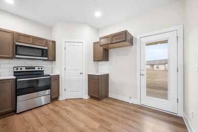 Kitchen featuring backsplash, appliances with stainless steel finishes, light countertops, light wood finished floors, and recessed lighting