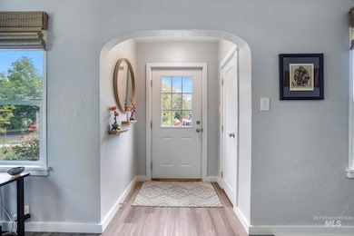 Doorway to outside featuring a textured wall and wood finished floors