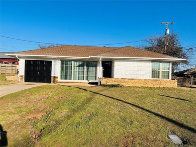 View of front of home with a front yard and a gara