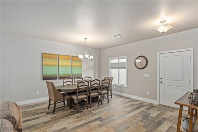 Dining area with wood finished floors and a chande