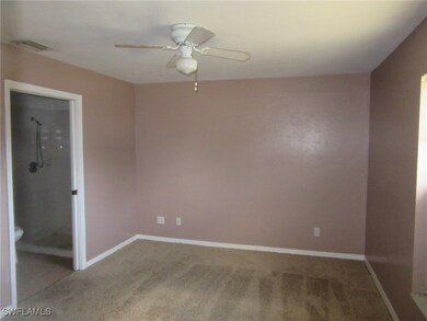 Empty room with light colored carpet, a ceiling fa