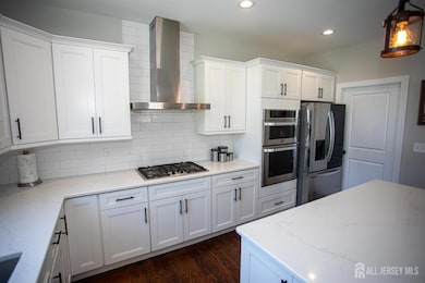 Stunning upgraded kitchen—complete with a double oven, stainless steel appliances, stylish backsplash, and a spacious breakfast bar. Sleek design and recessed lighting tie it all together.