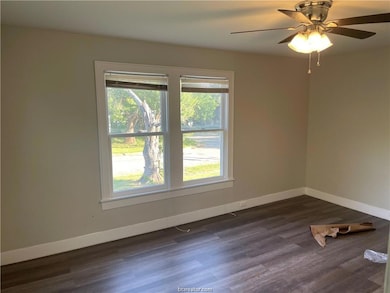 Unfurnished room with baseboards, dark wood finish