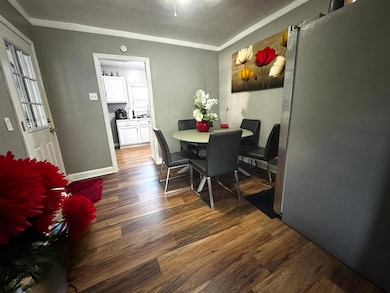 Dining area with ornamental molding and wood finished floors