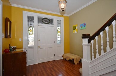 Welcoming, large foyer with hardwood floors and ro