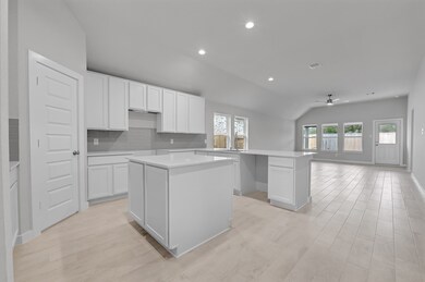 This stunning kitchen displays such beautiful white stained cabinets, custom neutral paint, quartz countertops, modern backsplash, separate kitchen island with extra storage, breakfast bar, recessed lighting, high ceilings and pantry.