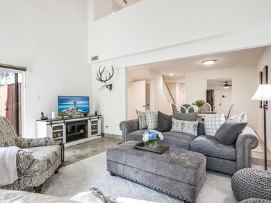 Tiled living area featuring a high ceiling and ba