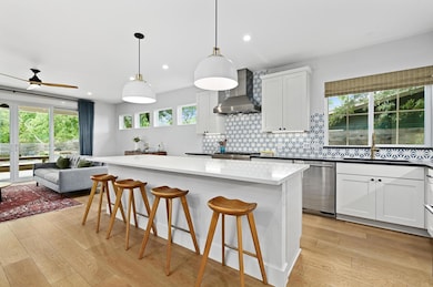 Kitchen with a sink, wall chimney exhaust hood, l