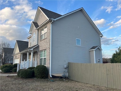 View of side of home with an attached garage, fenc