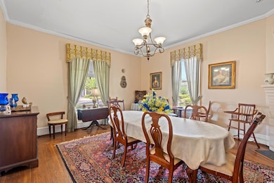 Dining room featuring crown molding, a chandelier, and wood finished floors