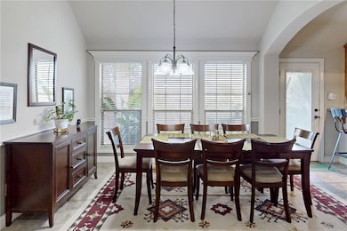 Dining area featuring arched walkways, a chandelie