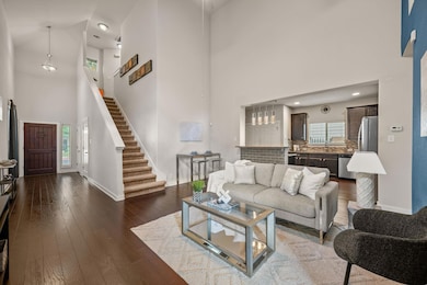 Living area with a towering ceiling, baseboards, 