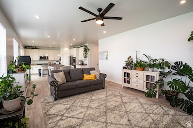 Living area featuring recessed lighting, light wood finished floors, and a ceiling fan