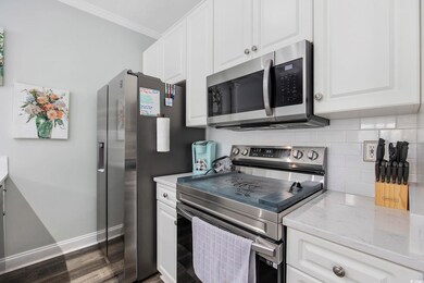Kitchen with ornamental molding, white cabinetry, 