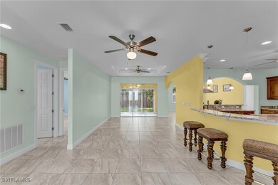 Kitchen with a ceiling fan, a breakfast bar, light