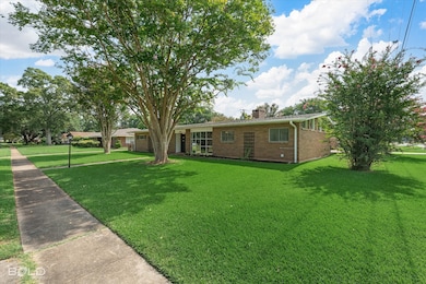 Single story home with brick siding, a front yard, and a chimney
