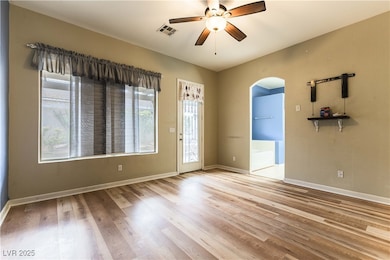 Primary room featuring arched walkways, ceiling fa