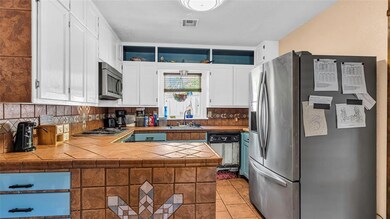 Kitchen featuring white cabinets, backsplash, ligh