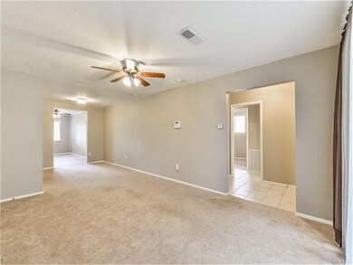 Sprawling front room with updated fixtures, paint, and carpeting.
