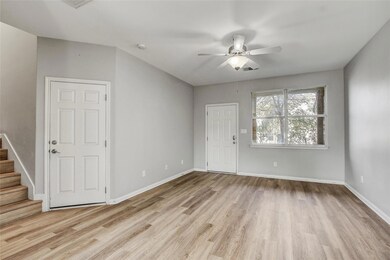 Entryway with wood finished floors, a ceiling fan