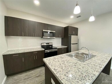 Kitchen featuring a sink, stainless steel appliances, a kitchen island with sink, visible vents, and backsplash