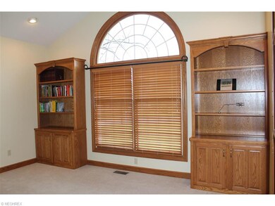 The office has a cathedral ceiling and 2 bookcases
