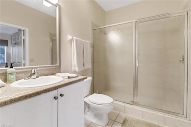 Bathroom with toilet, vanity, tile patterned floor