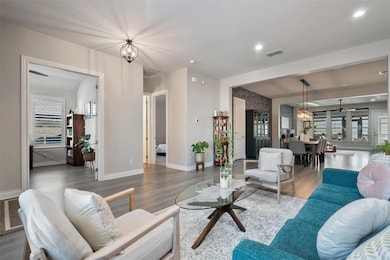 Living room with a chandelier, baseboards, wood f