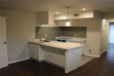 Kitchen featuring a sink, a peninsula, white cabi