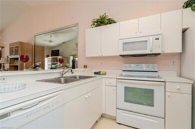 Kitchen with white cabinets, white appliances, lof